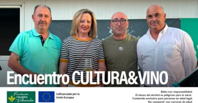 Fotografía de grupo del presidente de la D.O. Manchuela, José Enrique, junto al Delegado de Agricultura de Albacete, Ramón, y asistentes al Encuentro Cultura y Vino en Villamalea. De fondo, cartel del evento con el logotipo de la denominación y el de la Fundación Caja Rural de Villamalea.