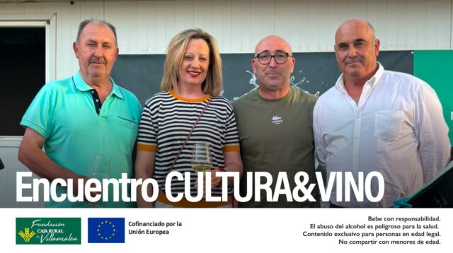 Fotografía de grupo del presidente de la D.O. Manchuela, José Enrique, junto al Delegado de Agricultura de Albacete, Ramón, y asistentes al Encuentro Cultura y Vino en Villamalea. De fondo, cartel del evento con el logotipo de la denominación y el de la Fundación Caja Rural de Villamalea.